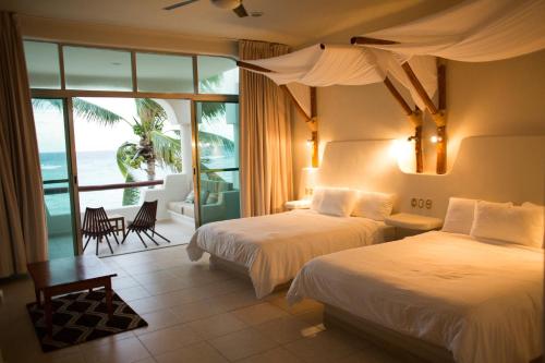 - une chambre avec 2 lits et une vue sur l'océan dans l'établissement Paamul Hotel, à Palmul