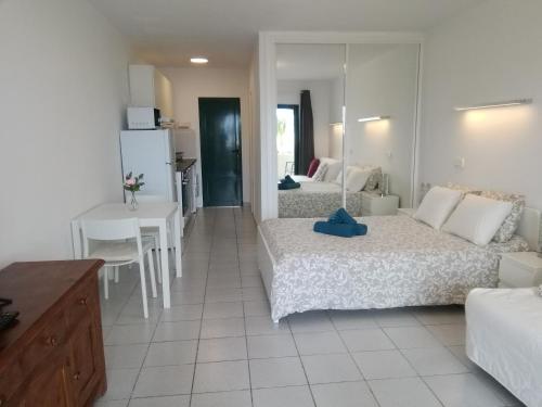um quarto com duas camas e uma mesa e uma cozinha em PLAYA ROCA MODERN STUDIO - Seafront Pool Complex em Costa Teguise