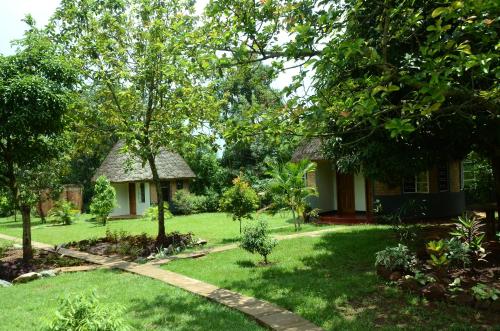 a garden with a small house and a grass yard at Tusubira village in Jinja