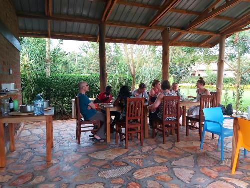 a group of people sitting at a table at Tusubira village in Jinja