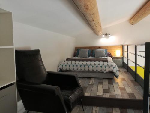a bedroom with a bed and a couch and a chair at les cerisiers de stella in Blauvac