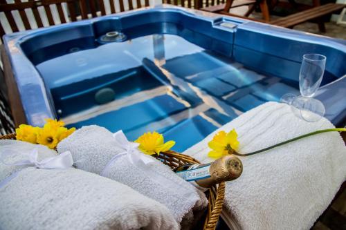 - un panier en osier avec des serviettes et des fleurs à côté d'une baignoire dans l'établissement Chalet Gallipoli, à Gallipoli