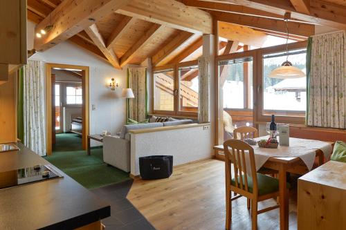 a kitchen and living room with a table and chairs at Fürmesli Appartements in Lech am Arlberg