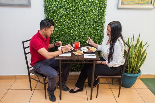 a man and woman sitting at a table eating food at Hotel Verona in San Pedro Sula