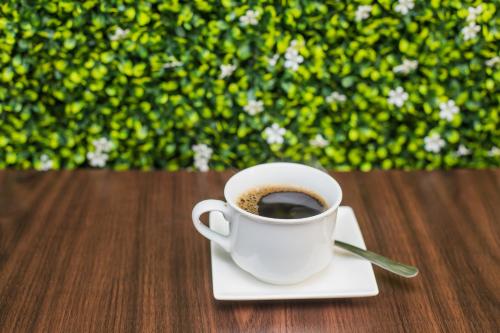 a cup of coffee sitting on a plate on a table at Hotel Verona in San Pedro Sula