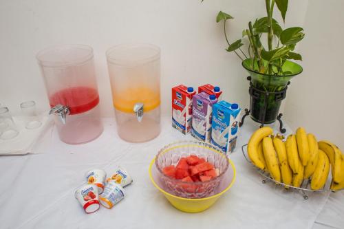 a counter with a bowl of fruit and some drinks at Hotel Verona in San Pedro Sula