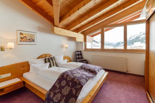 a bedroom with a bed and a large window at Fürmesli Appartements in Lech am Arlberg