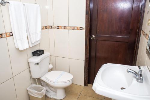 a bathroom with a toilet and a sink at Hotel Verona in San Pedro Sula