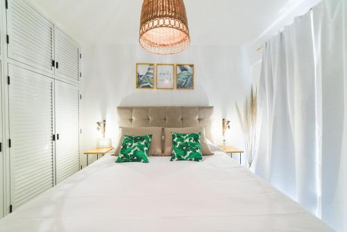 een slaapkamer met een groot wit bed met groene kussens bij Casa Nómada - Nueva Córdoba in Cordoba