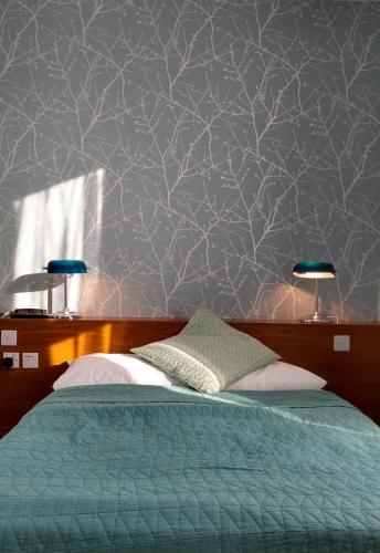 a bedroom with a bed with a green comforter at River Hotel in Oxford