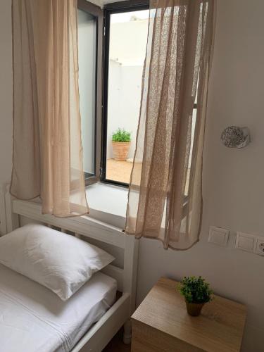 a bedroom with a window with a bed and a table at PALS Studios Lindos in Líndos