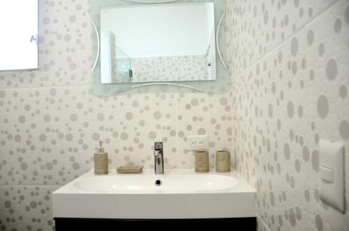 une salle de bains avec un lavabo blanc et un miroir dans l'établissement Caribe Apartament S&D el castillo dominicus Apartamento #9, à Bayahibe