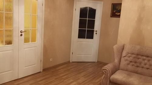 a living room with a chair and a door at Wine Casual Apartment in Chişinău