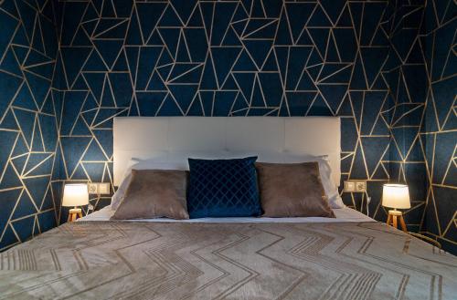 een slaapkamer met een bed met een geometrische muur bij Beach & Pool Sant Salvador - 150m from sea in Comarruga