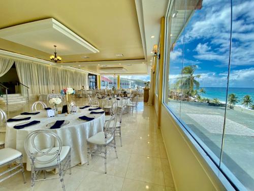 een restaurant met tafels en stoelen en uitzicht op de oceaan bij Hotel El Guajataca in Quebradillas