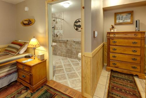 a bedroom with a shower and a bed and a dresser at Sea Parrot Inn in Seldovia