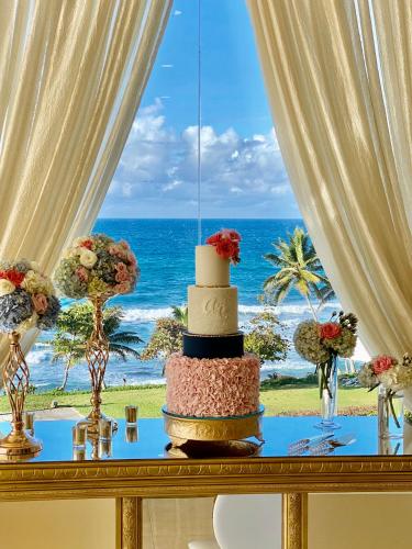 a wedding cake on a table with a view of the ocean at Hotel El Guajataca in Quebradillas
