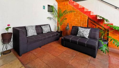 a living room with two couches and a brick wall at Ganesha Hotel in San Cristóbal de Las Casas