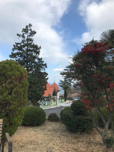 a view of a street with trees and a house at Namhae Frankfurt Pension in Namhae