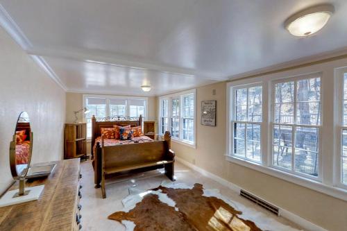 een slaapkamer met een bed en een kamer met ramen bij Historic Wilderness Retreat in Estes Park