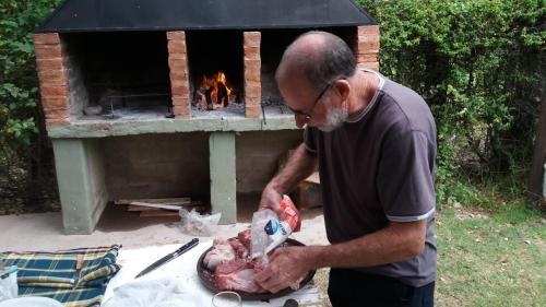 un homme préparant une dinde devant un four en briques dans l'établissement posada cerro los nogales, à Villa San Agustín
