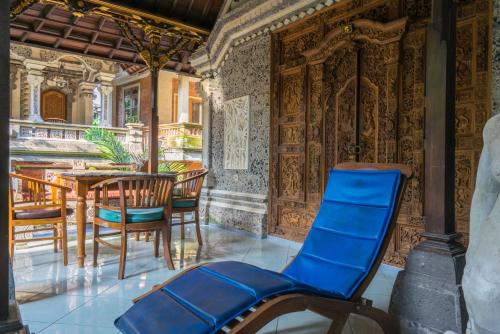 a patio with blue chairs and a table at Sania's House in Ubud