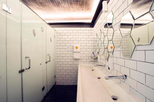 Baño con 2 lavabos y espejo en M Boutique Hostel, en Seminyak
