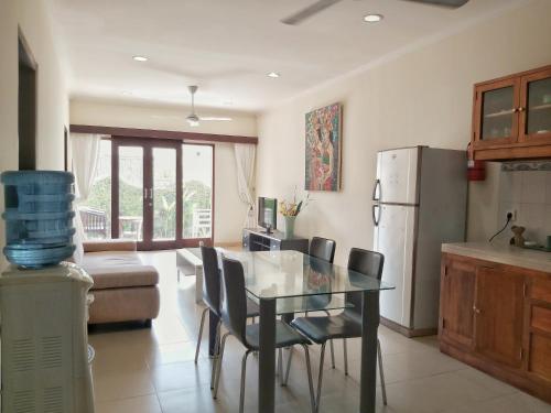una cucina con tavolo, sedie e frigorifero di Bali Paradise Apartments a Sanur