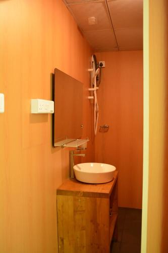 uma casa de banho com um lavatório branco e um espelho. em Shadow Grove Camping & Cabins Kitulgala em Kitulgala