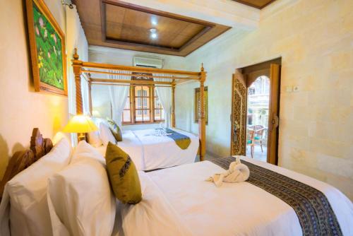 a bedroom with two beds with a teddy bear on them at Sania's House in Ubud