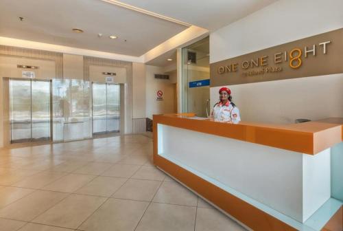 a woman standing behind a counter in a one eighty hotel lobby at 118 Residences by Travovo in George Town