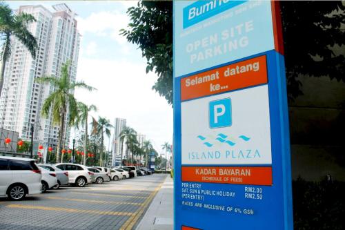 a sign on the side of a street with parked cars at 118 Residences by Travovo in George Town