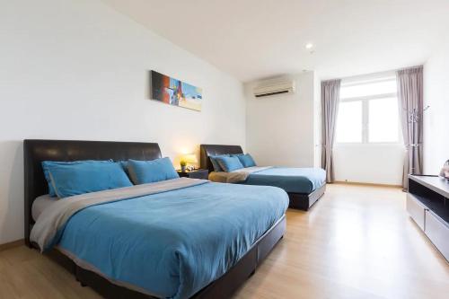 a large bedroom with two beds and a television at 118 Residences by Travovo in George Town