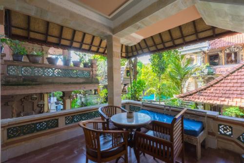 a balcony with a table and chairs and a view of a garden at Sania's House in Ubud