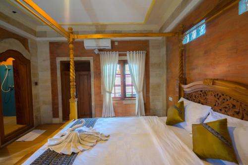 a bedroom with a bed with white sheets and a window at Sania's House in Ubud