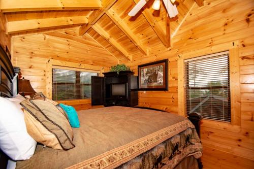 a bedroom with a bed in a wooden cabin at Hideaway Haven in Waldens Creek