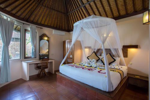 a bedroom with a bed with a canopy at Bali Dyana Villas in Seminyak