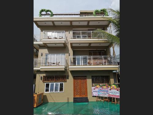 a building with a balcony and a swimming pool at Flamingo Avia Labuan Bajo in Labuan Bajo