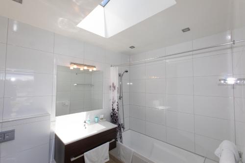 biała łazienka z umywalką i prysznicem w obiekcie Three Rivers Lodge w mieście Lake Tekapo