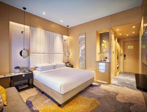 a bedroom with a large bed and a large window at Vivanta Bengaluru Residency Road in Bangalore