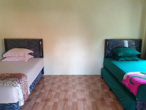 two beds sitting next to each other in a room at Nita's Homestay Banyuwangi in Banyuwangi