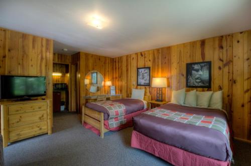 a bedroom with two beds and a flat screen tv at Powder House Lodge in Keystone