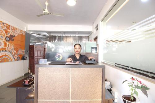 a woman sitting at a counter in a room at Treebo Trend Ivory House in Nagpur