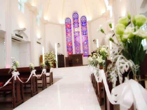 a church aisle with chairs and a stained glass window at Okayama International Hotel in Okayama