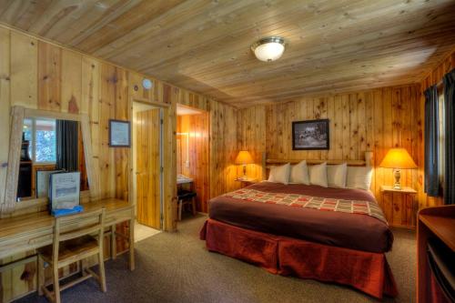 a bedroom with a bed in a room with wooden walls at Powder House Lodge in Keystone