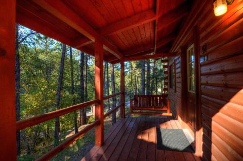 a porch of a cabin with a bench on it at Powder House Lodge in Keystone