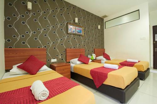 a bedroom with two beds with red and yellow at COOP HOTEL PUTRAJAYA & CYBERJAYA in Kampung Dengkil