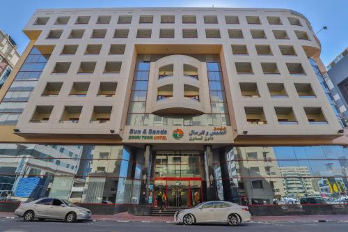 two cars parked in front of a building at Sun And Sands Downtown in Dubai