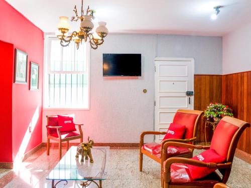 uma sala de estar com duas cadeiras e uma mesa de vidro em OYO Hotel Lindoia, Petropolis em Petrópolis