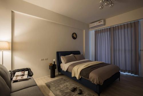 a bedroom with a bed and a couch at 單眼皮民宿 Single Eyelid Hostel in Yilan City